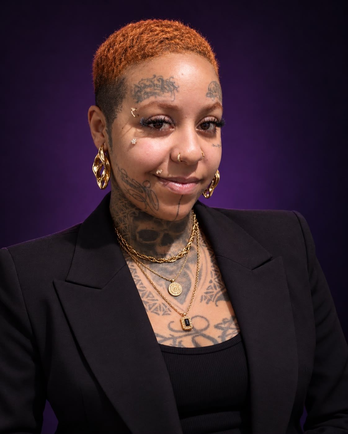 Eliza Azile sorrindo, de blazer preto e acessórios dourados, sobre fundo violeta